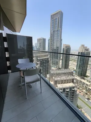 a table and chair on the balcony of a building at 2BD Luxury Opera District Apt Downtown in Dubai
