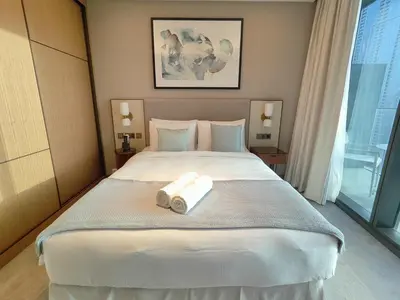 a bedroom with a large bed with two towels on it at 2BD Luxury Opera District Apt Downtown in Dubai