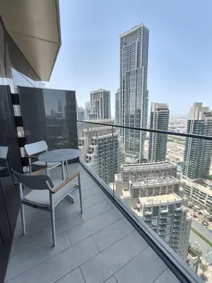 a balcony with a table and chair on top of a city at 2BD Luxury Opera District Apt Downtown in Dubai