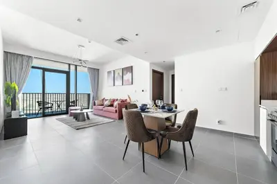 a kitchen and living room with a table and chairs at Stylish 1 Bedroom High Floor in Creek Edge in Dubai