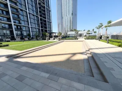 a sidewalk in the middle of a city with tall buildings at Stylish 1 Bedroom High Floor in Creek Edge in Dubai
