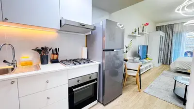 a kitchen with a stainless steel refrigerator and a sink at Dubai Marina - Modern Design Studio Apartment, Marina Diamond 2 in Dubai