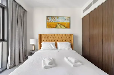 a bedroom with a bed with two white towels on it at Stylish 1 Bedroom High Floor in Creek edge in Dubai