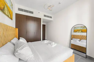 a bedroom with a large bed and a mirror at Stylish 1 Bedroom High Floor in Creek edge in Dubai