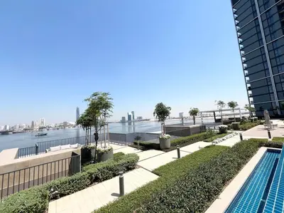 a swimming pool with a view of the water at Stylish 1 Bedroom High Floor in Creek Edge in Dubai