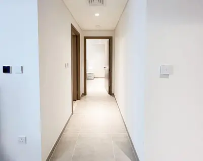 a hallway with white walls and a tile floor at Elegant 1 bedroom in Creek Edge in Dubai
