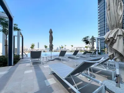 a row of lounge chairs on the roof of a building at Elegant 1 bedroom in Creek Edge in Dubai