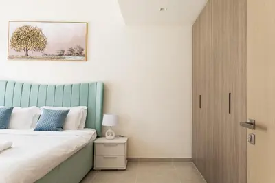 a bedroom with a bed with a blue headboard at Elegant 1 bedroom in Creek Edge in Dubai