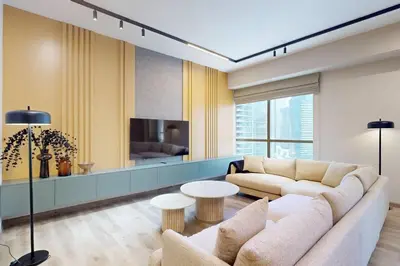 a living room with a couch and a tv at Rimal 1 - Opulant Two Bedroom in Dubai