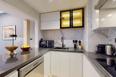 a kitchen with white cabinets and a sink at Rimal 1 - Opulant Two Bedroom in Dubai