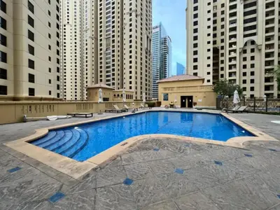 a large swimming pool in a city with tall buildings at Rimal 1 - Opulant Two Bedroom in Dubai