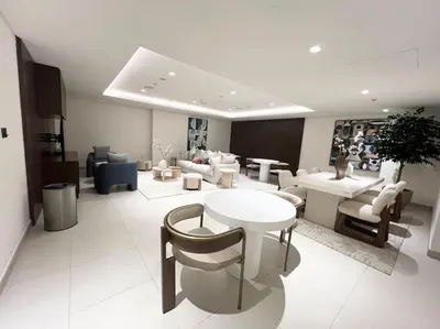 a living room with tables and couches and chairs at Elegant 1 bedroom in Creek Edge in Dubai