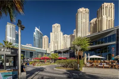 a city with tall buildings and tables and umbrellas at Prime Spacious Studio with Vibrant Vibes in JBR By SWEET HOMES in Dubai