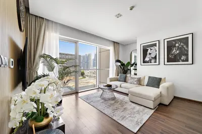a living room with a couch and a large window at Stonetree - Brand New 1 BR in Prime Location in Dubai