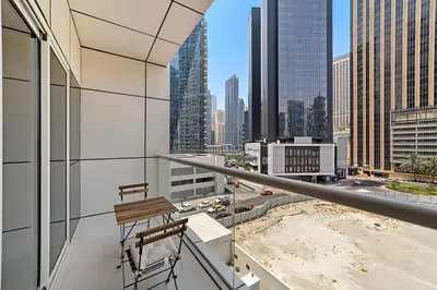 a balcony with a chair and a view of a city at Stonetree - Brand New 1 BR in Prime Location in Dubai