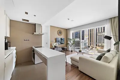 a kitchen and living room with a couch and a table at Stonetree - Brand New 1 BR in Prime Location in Dubai