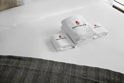 three towels sitting on top of a bed at Stonetree - Brand New 1 BR in Prime Location in Dubai