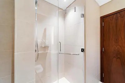 a shower with a glass door in a bathroom at Chic 1-Bed Near Marina Promenade - 5 min to Tram in Dubai