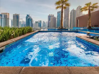 a swimming pool with a city skyline in the background at Chic 1-Bed Near Marina Promenade - 5 min to Tram in Dubai