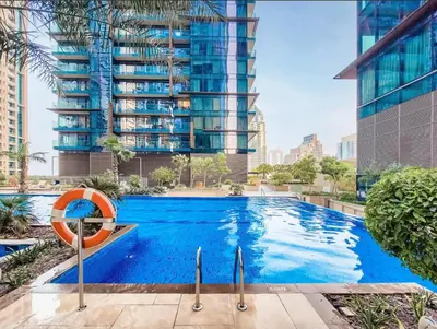 a swimming pool in a city with a tall building at Chic 1-Bed Near Marina Promenade - 5 min to Tram in Dubai