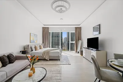 a white living room with a couch and a bed at Big Studio - WOW facilities in Dubai