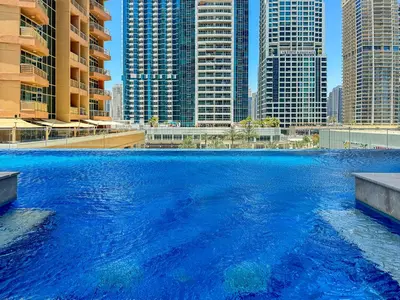 a large pool of blue water with tall buildings at Big Studio - WOW facilities in Dubai