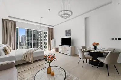 a hotel room with a bed and a dining room at Big Studio - WOW facilities in Dubai