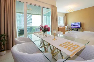 a dining room with a glass table and white chairs at Stunning Marina view apartment In Marina sail tower by Truebleu vacation homes in Dubai