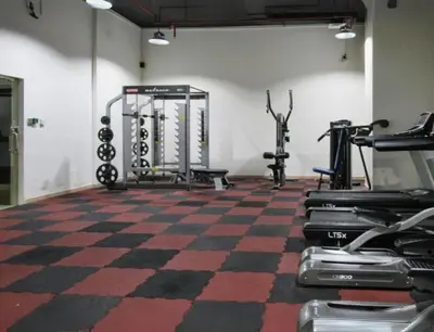 a gym with several tread machines in a room at Very Convenient Apartment steps to Metro and Marina Mall Managed by SunnyHomes in Dubai