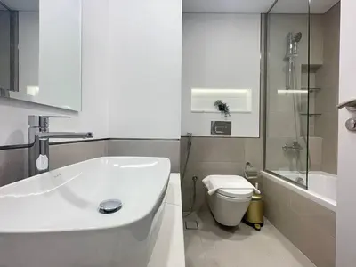 a white bathroom with a toilet and a sink at Luxe & Comfy Madinat Jumeirah - Apartment with Scenic Views - Pool Managed by SunnyHomes in Dubai