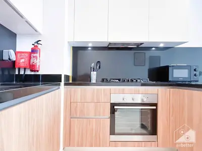 a kitchen with wooden cabinets and a stove top oven at Stylish One-Bedroom Getaway in Business Bay in Dubai