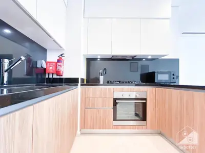 a kitchen with wooden cabinets and a sink at Stylish One-Bedroom Getaway in Business Bay in Dubai