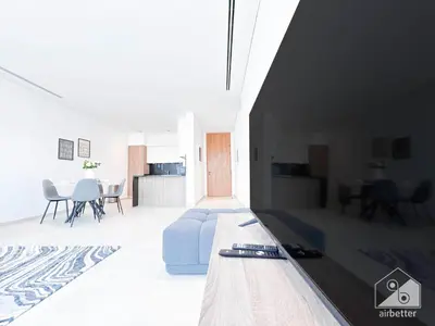 a living room with a blue couch and a table at Stylish One-Bedroom Getaway in Business Bay in Dubai