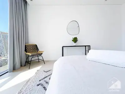 a bedroom with a bed and a chair and a window at Stylish One-Bedroom Getaway in Business Bay in Dubai