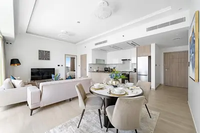 a dining room and living room with a table and chairs at Big 1BD in JLT - Pool, Game Zone in Dubai