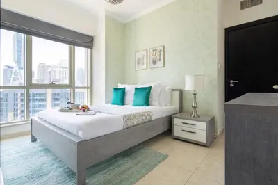 a bedroom with a large bed and a large window at Frank Porter - Al Majara Tower 2 in Dubai