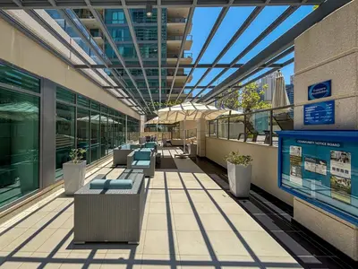 a hallway of a building with benches and a glass ceiling at Frank Porter - Al Majara Tower 2 in Dubai