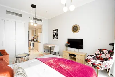 a bedroom with a bed and a living room with a tv at Sleek Studio in Damac Hills - Premium Living with Top-Class Amenities, Managed by Think Realty in Dubai