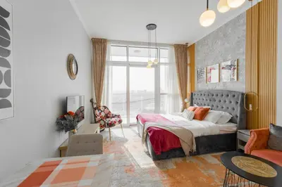 a bedroom with a bed and a living room at Sleek Studio in Damac Hills - Premium Living with Top-Class Amenities, Managed by Think Realty in Dubai