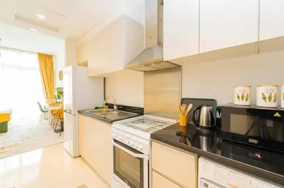 a kitchen with a stove and a microwave at Golf View Studio in Damac Hills - Luxury Living, Exclusive Amenities, by Think Realty in Dubai