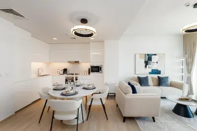 a living room with a table and chairs and a couch at Palace Residence, Dubai Creek Harbour - Mint Stay in Dubai