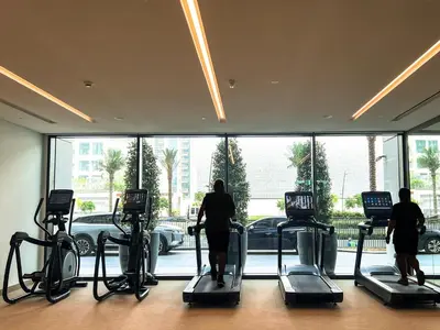 a group of people exercising on cardio machines in a gym at Palace Residence, Dubai Creek Harbour - Mint Stay in Dubai