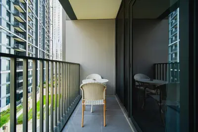 a balcony with a table and chairs and buildings at SettlerHomes - Chic Creek Edge 1BR With Harbour View in Dubai