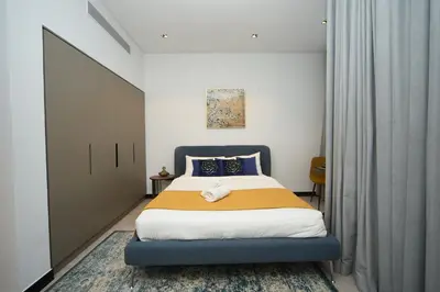 a bedroom with a large bed with a blue headboard at Cosy Studio on the Binghatti Canal in Dubai