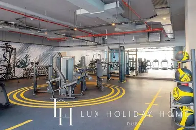 a gym with treadmills and machines in a room at LUX The Ultimate Marina View Suite in Dubai
