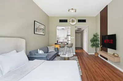 a bedroom with a bed and a living room at Chic studio near metro at Discovery Gardens in Dubai