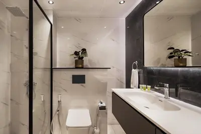 a bathroom with a sink and a toilet and a mirror at Chic studio near metro at Discovery Gardens in Dubai