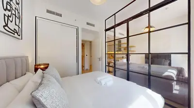 a bedroom with a white bed and a large window at Socio Tower 2 - Neat One Bedroom in Dubai