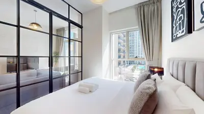 a bedroom with a white bed and a large window at Socio Tower 2 - Neat One Bedroom in Dubai