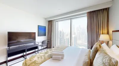 a hotel room with a large bed and a large window at Vacationer l Bright 1 Bedroom l Marina & Yacht Views l Pool access & Free Wi-Fi in Dubai